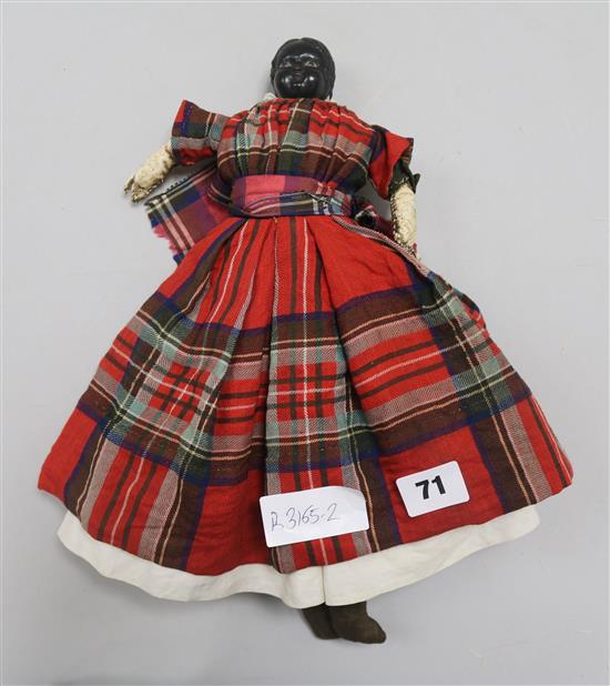 A Victorian doll wearing a tartan dress